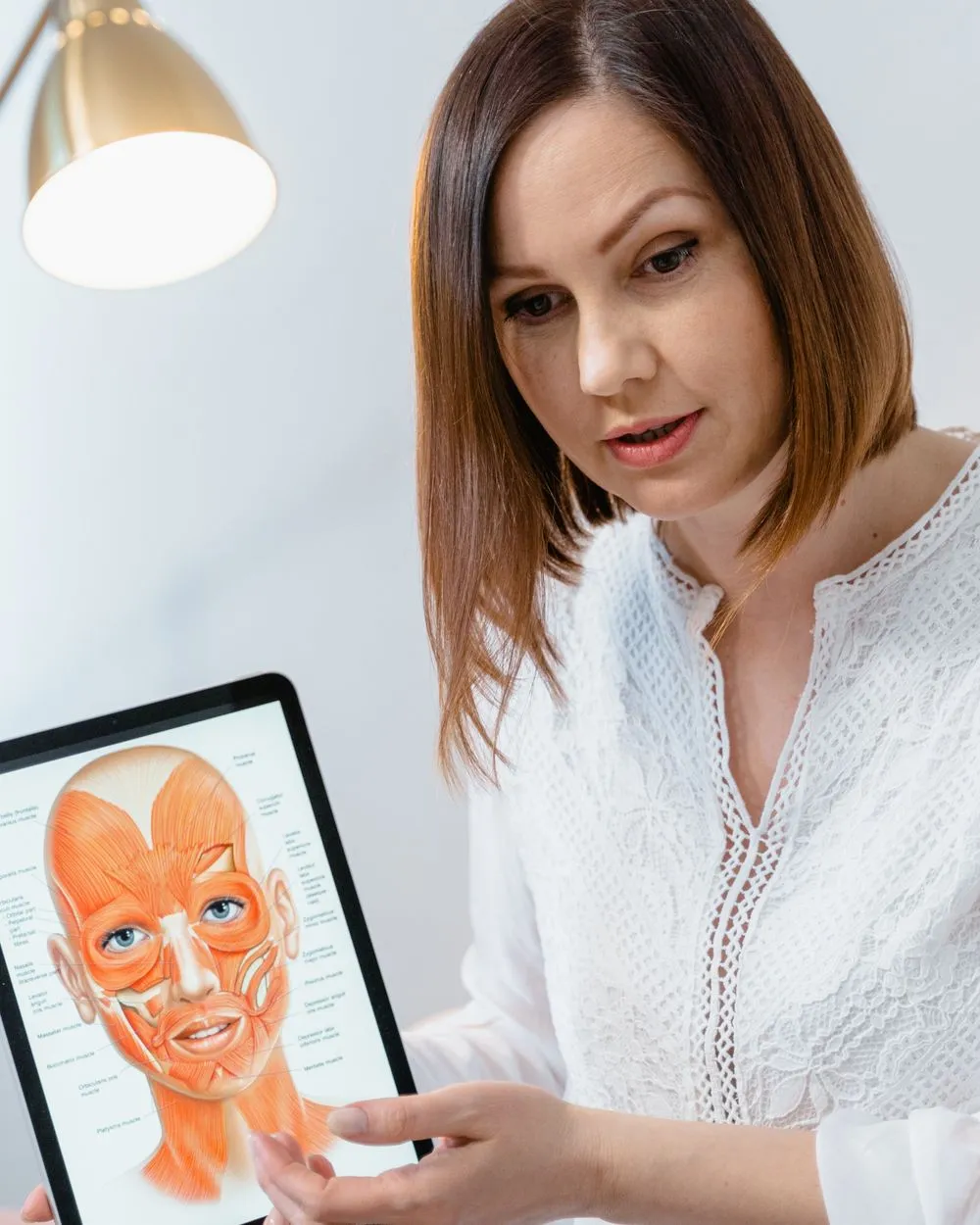 Analyse du visage à l'aide d'une planche d'anatomie sur tablette