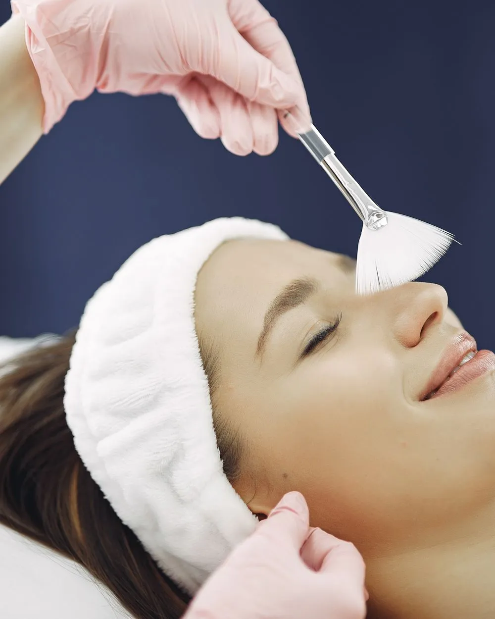 Application d'une solution de peeling au pinceau sur le visage